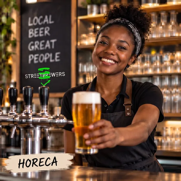 A smiling bartender holds out a fresh beer at the bar